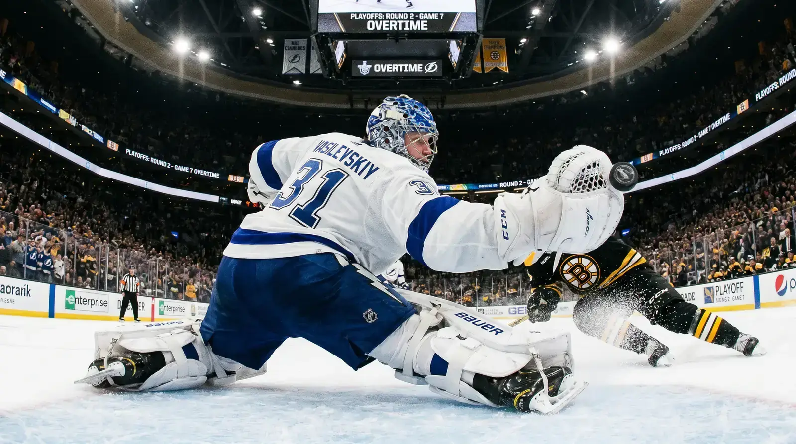 Elite NHL goaltender making a sprawling save during a playoff game