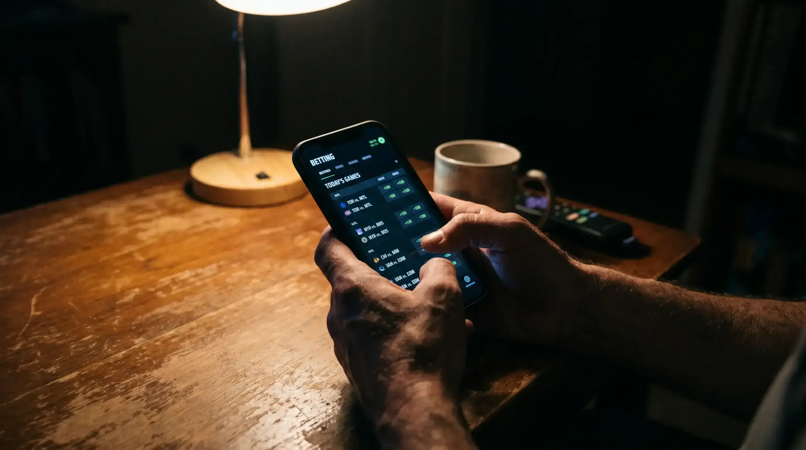 Person checking hockey betting odds on a smartphone late at night