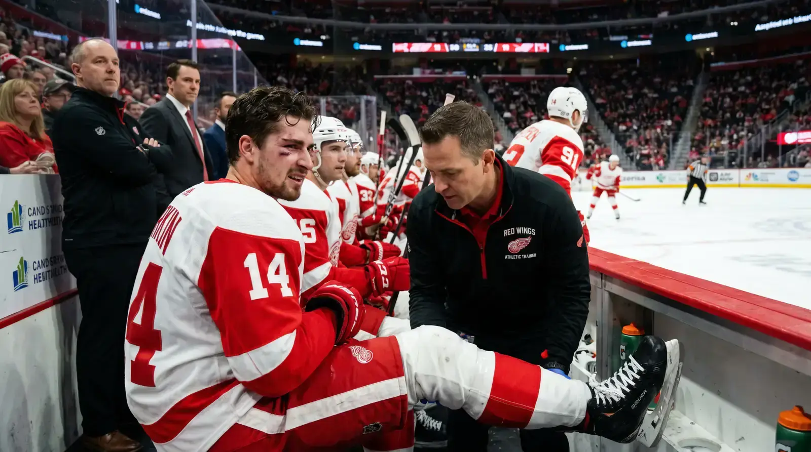 Hockey player being assessed by a trainer on the bench during a game