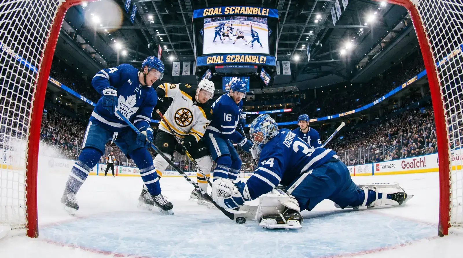 NHL game in progress with multiple players near the crease during a high-scoring match