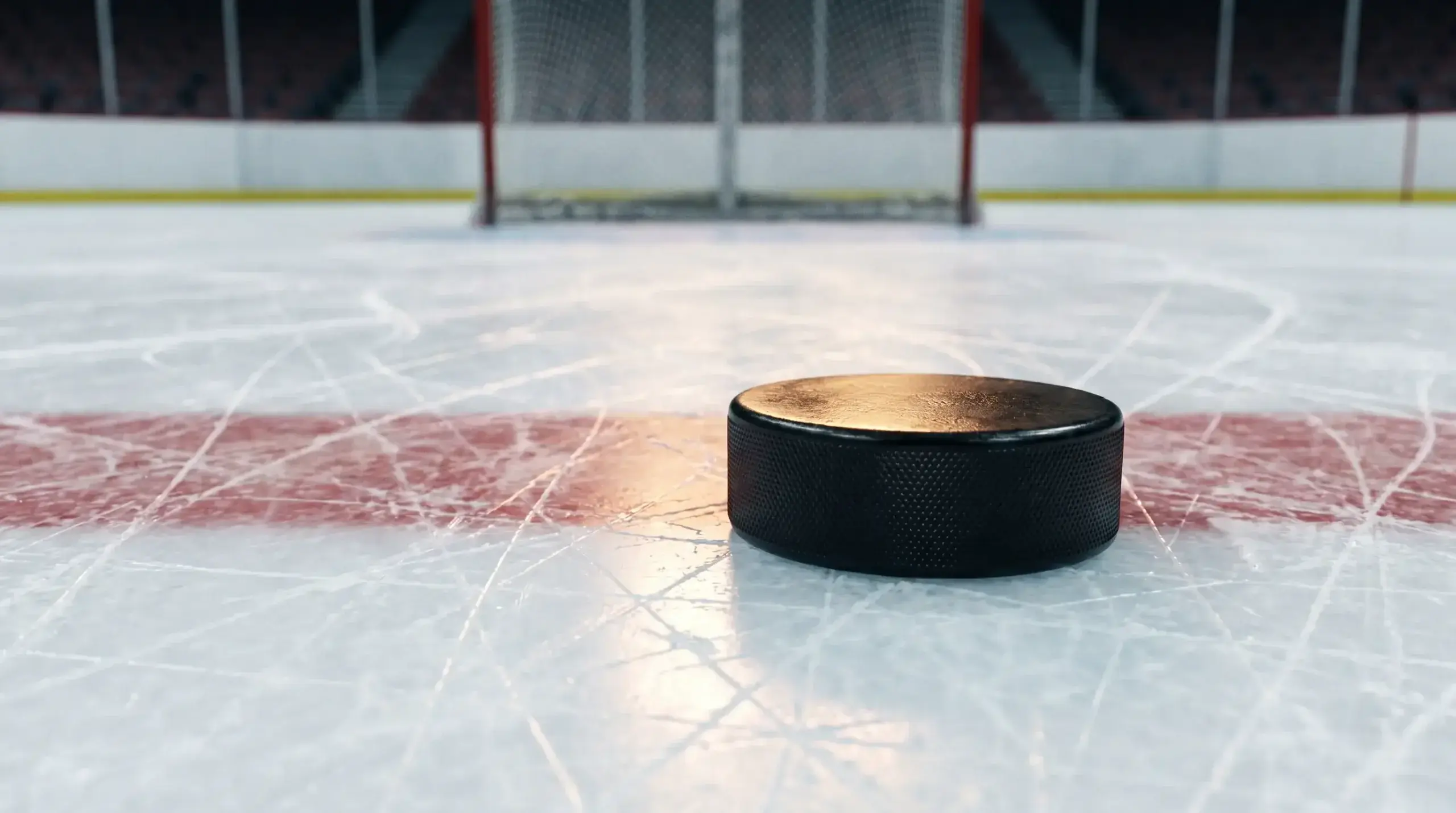 Ice hockey puck on rink surface near goal line illustrating puck line handicap betting