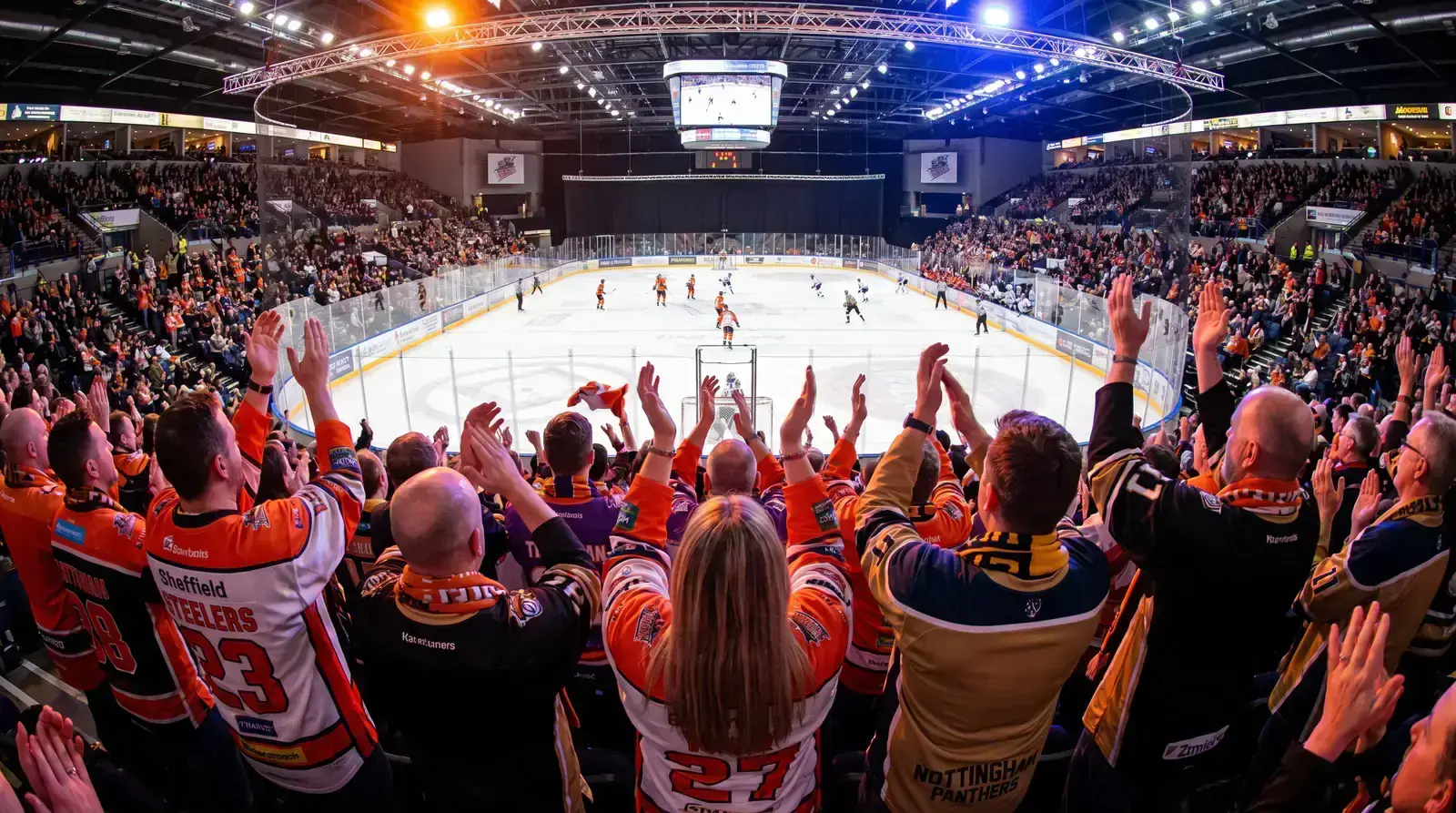 Ice hockey fans in a UK arena cheering during a professional match
